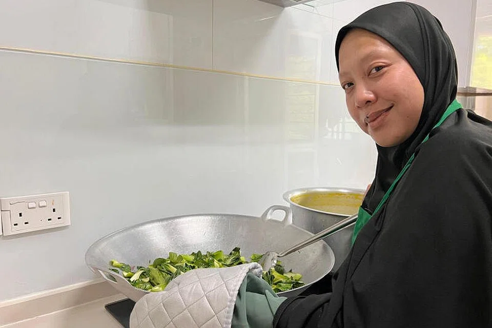 BERNIAGA SAMBIL BERAMAL: Setiap petang lepas menyiapkan tempahan pelanggan, Cik Razlina Razak, menyusun makanan untuk diderma di depan rumahnya di Blok 450B Bukit Batok West Avenue 6 bagi mereka yang memerlukan. - Foto ihsan RAZLINA RAZAK