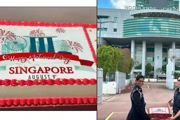 HADIAHKAN KEK: Timbalan Ketua Imigresen Bangunan Sultan Iskandar, dikenal pasti sebagai Puan Vimala telah menyerahkan kek kepada Timbalan Komander Woodlands Tong Weijie di Pusat Pemeriksaan Woodlands sempena ulang tahun Singapura ke-58. 