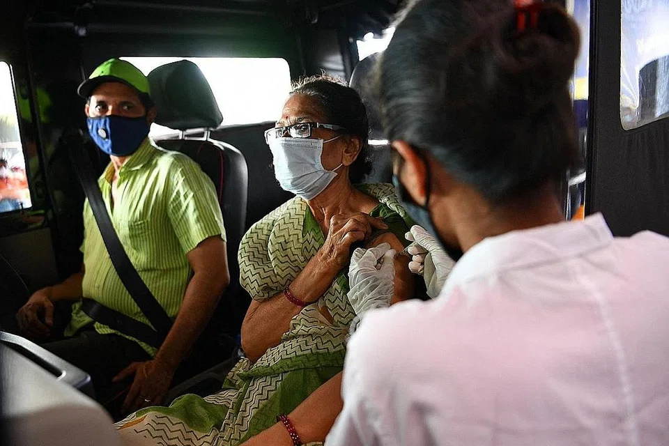 VARIAN BARU DIKESAN: Seorang pekerja kesihatan memberi suntikan vaksin Covid-19 kepada seorang wanita di pusat vaksinasi pandu lalu di sebuah pusat beli-belah di Mumbai, di Maharashtra, kelmarin. Negeri itu antara tiga negeri di India yang dikesan mempunyai kes Covid-19 daripada varian baru Delta Plus. - Foto AFP