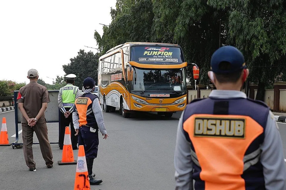 KAWALAN KETAT: Sebuah bas tiba di pusat pemeriksaan di Jakarta, kelmarin. Pemerintah Indonesia melaksanakan sekatan perjalanan sepanjang perayaan Aidilfitri antara 6 hingga 17 Mei dalam satu usaha mengekang penularan jangkitan dalam kalangan masyarakat. - Foto EPA-EFE