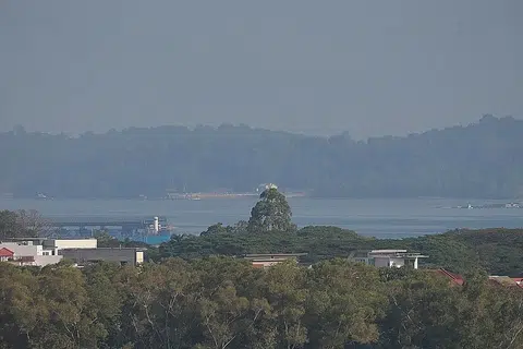 JEREBU: Pulau Ubin tampak diselimuti jerebu semasa gambar ini dirakam pada 9 pagi semalam dari perumahan di Pasir Ris. - Foto BH oleh KEVIN LIM