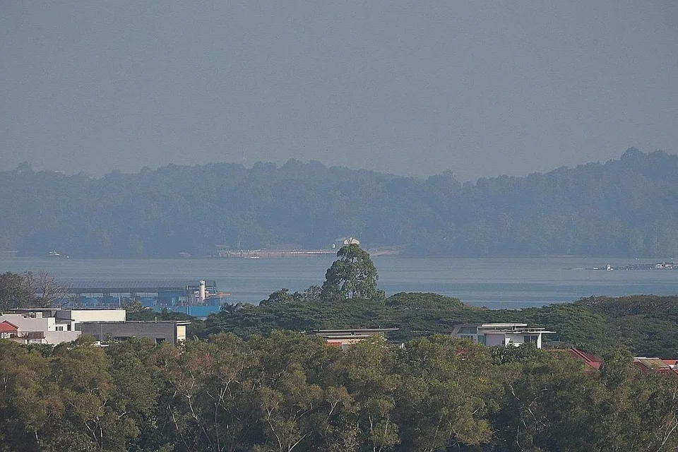 JEREBU: Pulau Ubin tampak diselimuti jerebu semasa gambar ini dirakam pada 9 pagi semalam dari perumahan di Pasir Ris. - Foto BH oleh KEVIN LIM