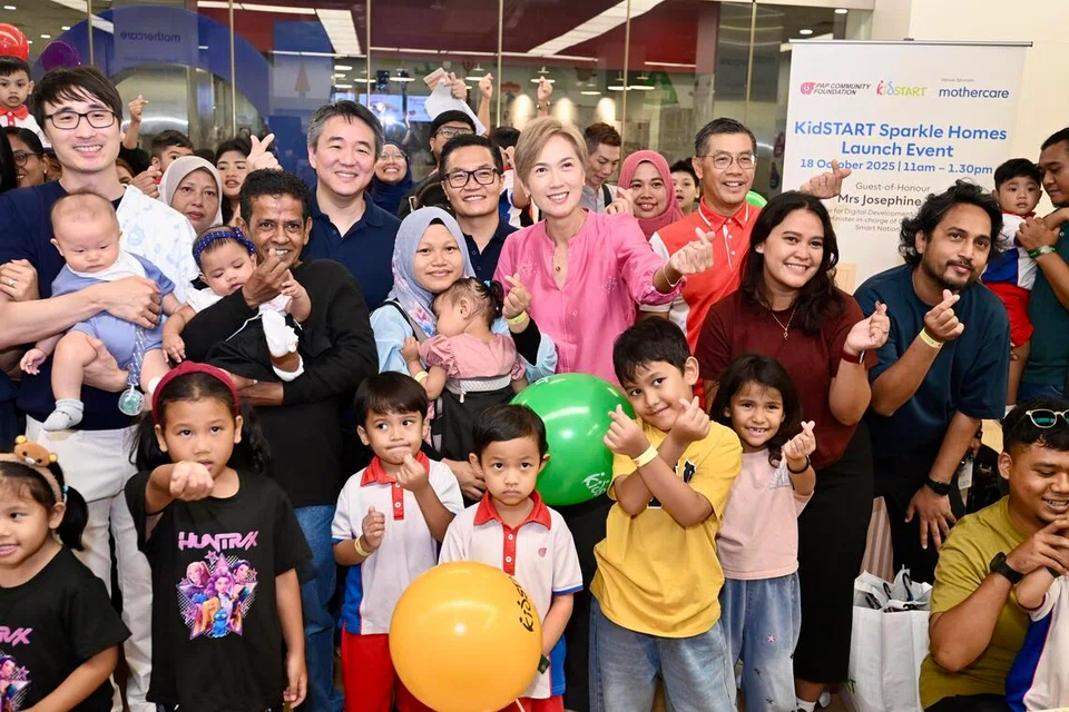 Menteri Penerangan dan Pembangunan Digital merangkap Menteri Bertanggungjawab bagi Negara Bijak dan Keselamatan Siber, Cik Josephine Teo (tengah) bersama keluarga yang menghadiri pelancaran KidSTART Sparkle Homes di Mothercare, Habourfront Centre, pada 18 Oktober. 