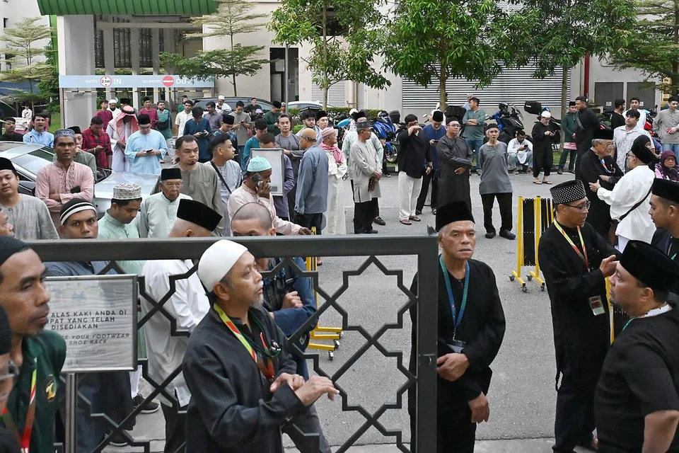 Anggota jemaah di luar perkarangan Masjid Al-Iman menunggu giliran untuk menunaikan solat Hari Raya sesi kedua di masjid tersebut pada 31 Mac, iaitu pada 8.45 pagi.
