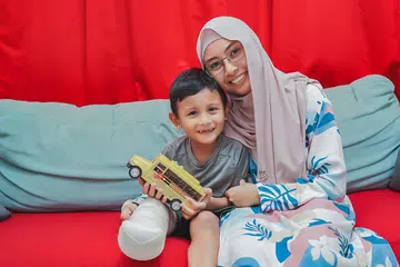 MASIH MAMPU UKIR SENYUM: Walaupun terpaksa mengharungi dugaan besar pada usia kecil setelah kehilangan sebahagian kaki kanannya, Imraan Danish Nur Hisyam masih lagi bersemangat dan ceria meneruskan hidup bersama ibu kesayangan, Cik Juliana Jomiri. 