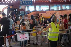 BERI KHIDMAT: Seorang kakitangan Transtar Travel kelihatan mengarahkan penumpang menuju ke Malaysia menerusi VTL di Pusat Pertukaran Bas Sementara Woodlands pada 20 Disember 2021. - Foto fail