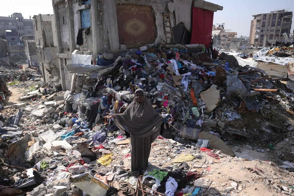Seorang wanita Palestin berada di tapak kemusnahan di Jabalia, di utara Gaza pada 17 Februari.