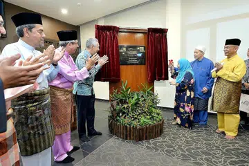 PEMBUKAAN RASMI: Puan Noor Aishah dengan bantuan anaknya, Dr Imran (berbaju biru), merasmikan pembukaan Masjid Yusof Ishak sambil disaksikan oleh (dari kiri) Ketua Eksekutif Muis Haji Abdul Razak Maricar, Dr Yaacob, Perdana Menteri Encik Lee dan pengerusi masjid, Encik Ayub. - Foto M.O. SALLEH