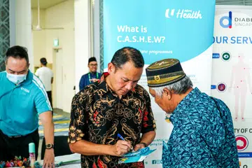 INISIATIF UNTUK WARGA EMAS: Encik Mohd Fahmi Aliman (kiri) beramah-tamah bersama Encik Samsudin Hashim, yang mengunjungi pameran kesihatan masyarakat anjuran Pertapis khusus bagi warga emas di Masjid Al-Ansar pada Jumaat. 