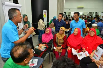 DIALOG RAPAT HARI KEBANGSAAN: Timbalan pengerusi MAEC Siglap, Encik Najib Ahmad (kiri) memimpin perbincangan dengan penduduk, disaksikan oleh penasihat pertubuhan akar umbi GRC East Coast, Dr Mohamad Maliki Osman (baju biru gelap) dan pengerusi MAEC, Encik Yacob Hussain (di kiri beliau.) - Foto KELAB MASYARAKAT SIGLAP
