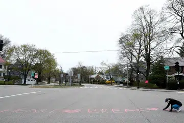 PATAH HATI: Seorang penduduk dilihat menghiasi Commonwealth Avenue, yang digelar 'Heartbreak Hill' (Bukit Patah Hati) dan merupakan sebahagian laluan Maraton Boston. Perlumbaan popular itu akhirnya dibatalkan dek Covid-19, setelah ditangguh ke 14 September dari 20 April. - Foto AFP