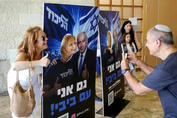 Orang ramai bergambar dengan papan foto yang memaparkan imej Perdana Menteri Israel, Encik Benjamin Netanyahu, pada hari pengundian pemilihan senarai calon parti Likud menjelang pilihan raya umum Israel pada Oktober, di Baitulmakdis pada 17 Ogos 2026.