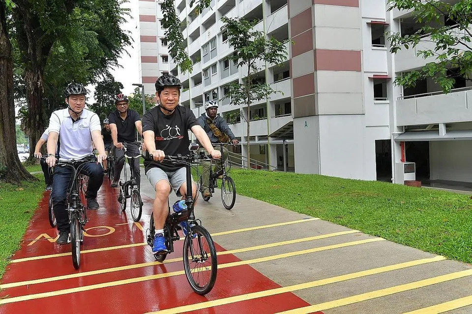 BERBASIKAL DI ANG MO KIO: Encik Khaw (depan), Dr Lam (kiri) dan Dr Janil (tengah) berbasikal di keliling estet Ang Mo Kio, yang diiktiraf sebagai Bandar Berbasikal dan Berjalan Kaki pada 2014. - Foto BH oleh NG SOR LUAN