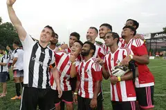 TEMUI PEMINAT SINGAPURA: Bekas kapten Manchester United Gary Neville (memegang telefon bimbit) memetik 'wefie' dengan pemain Piala Arena bersama dengan seorang lagi legenda United, Ryan Giggs (barisan belakang, tiga dari kanan). - Foto THE ARENA