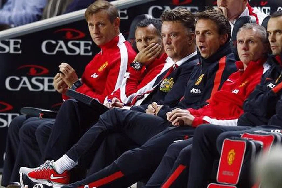 SUASANA MURAM: Pengurus Manchester United, Louis van Gaal (tiga dari kiri), serta pembantunya, Ryan Giggs (di kanannya), menyaksikan pasukan mereka dibelasah kelab yang bermain dalam Divisyen Tiga, MK Dons.