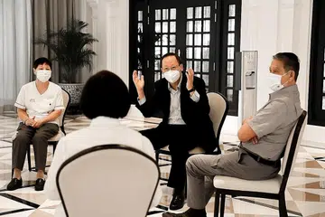 LATIH SEMULA PEKERJA: Dalam lawatannya ke Raffles Hotel Singapore semalam, Dr Tan See Leng (dua dari kanan) berpeluang menemui beberapa pekerja, termasuk pekerja matang yang telah menjalani latihan semula untuk menggunakan teknologi dan sistem baru bagi pekerjaan mereka. - Foto ZAOBAO