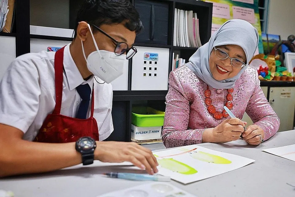 LAWAT SEKOLAH: Presiden Halimah Yacob menyertai kelas seni bersama pelajar, Muhammad Hadi Azim Azhar, 14 tahun, semasa lawatannya di Sekolah Tanglin pada Selasa. - Foto ST