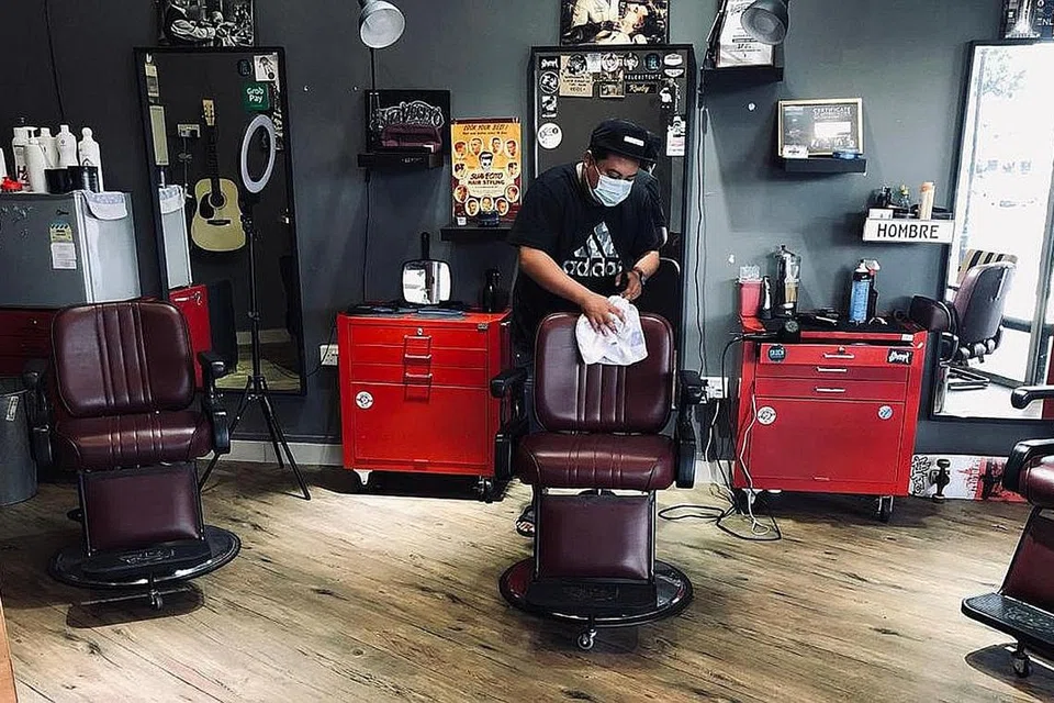 SEDIA TERIMA PELANGGAN: Encik Khairul sedang membersihkan kedainya Hombre Barbers semalam. Pekerjanya pula telah melalui latihan dalam talian untuk mendidik mereka mengenai jarak selamat serta menjaga kebersihan sewaktu memberi perkhidmatan. - Foto ihsan MOHAMMAD KHAIRUL AIZAT SALLEH