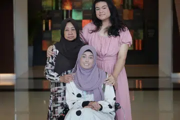 BERBAKTI KEPADA IBU: Cik Nur Aqilah Andrelina Mohammad Andi Sufian (kanan)  menerima Anugerah Pengasuh Inspirasi. Bersama beliau ialah neneknya Azizah Wannor (kiri), 68 tahun, dan ibunya,  Cik Haslina Wannor, 43 tahun, semasa majlis Anugerah Pesakit & Pengasuh Inspirasi Kesihatan Singapura pada Isnin.