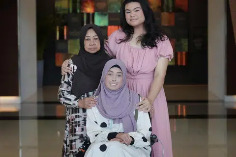 BERBAKTI KEPADA IBU: Cik Nur Aqilah Andrelina Mohammad Andi Sufian (kanan)  menerima Anugerah Pengasuh Inspirasi. Bersama beliau ialah neneknya Azizah Wannor (kiri), 68 tahun, dan ibunya,  Cik Haslina Wannor, 43 tahun, semasa majlis Anugerah Pesakit & Pengasuh Inspirasi Kesihatan Singapura pada Isnin.