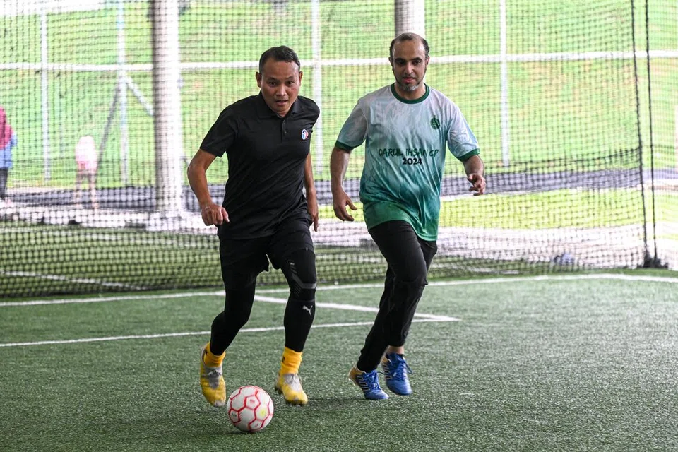 Mayor Majlis Pembangunan Masyarakat (CDC) South East, Encik Mohd Fahmi Aliman (kiri), dan Ketua Pegawai Eksekutif MTFA, Dr Abdul Qader al-Aidaroos, turut serta dalam perlawanan akhir, bermain bersama kakitangan Darul Ihsan.