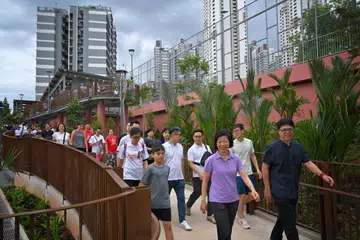 Menteri Negara Kanan (Ehwal Luar merangkap Pembangunan Negara), Cik Sim Ann (tengah, barisan hadapan) berjalan bersama penduduk di laluan tanjakan yang menuju ke penghubung taman itu, dalam satu kegiatan senaman pada 30 Jun. 