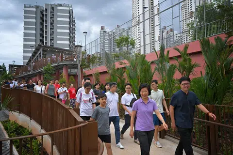 Menteri Negara Kanan (Ehwal Luar merangkap Pembangunan Negara), Cik Sim Ann (tengah, barisan hadapan) berjalan bersama penduduk di laluan tanjakan yang menuju ke penghubung taman itu, dalam satu kegiatan senaman pada 30 Jun. 