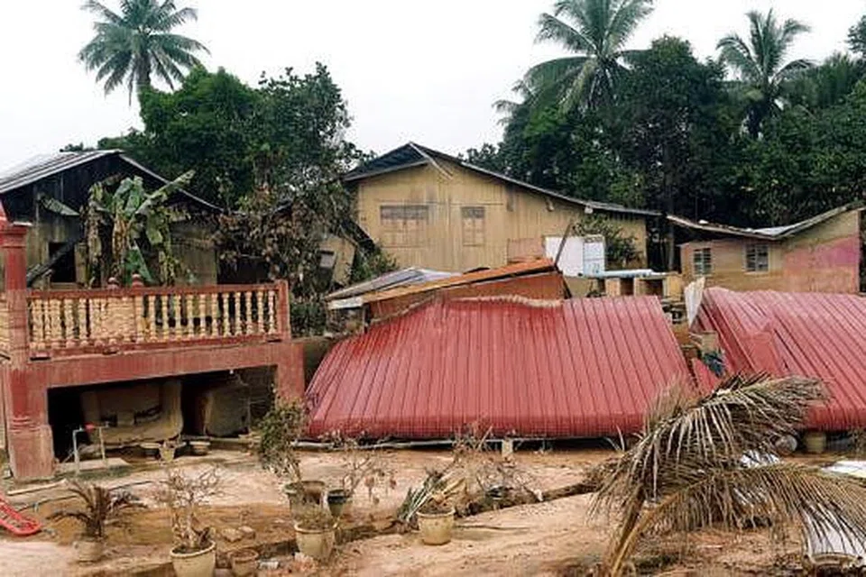 ANGKARA DERUAN ARUS BANJIR: Bumbung dan dinding rumah di Kampung Guchil Lama di Kuala Kerai ini menyembah bumi dan lantas menyebabkan penghuninya hilang tempat berteduh.