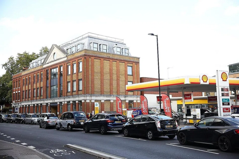 BERATUR PANJANG: Amaran tentang kekurangan bekalan minyak akhir minggu lalu menyebabkan pembelian panik, dengan barisan panjang kereta menunggu berjam-jam untuk mengisi minyak. - Foto REUTERS