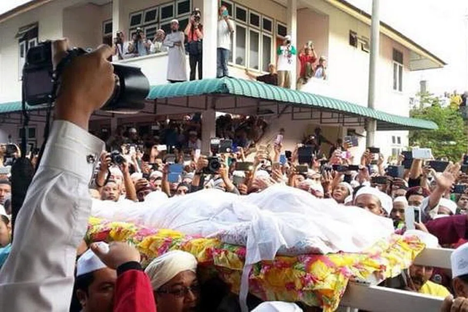 PENGHORMATAN TERAKHIR: Ribuan orang menziarahi jenazah Allahyarham Mursyidul Am PAS, Datuk Nik Abdul Aziz Nik Mat, di rumahnya sebelum jenazahnya dibawa ke Tanah Perkuburan Islam Pulau Melaka di sini, semalam. - Foto-foto UTUSAN ONLINE