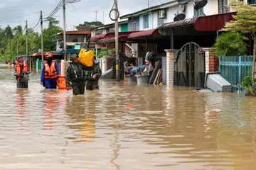 PINDAHKAN MANGSA: Pihak keselamatan membantu mangsa banjir di Kota Tinggi, Johor, berpindah ke pusat pemindahan sementara kerana keadaan banjir semakin buruk pada 8 Januari.