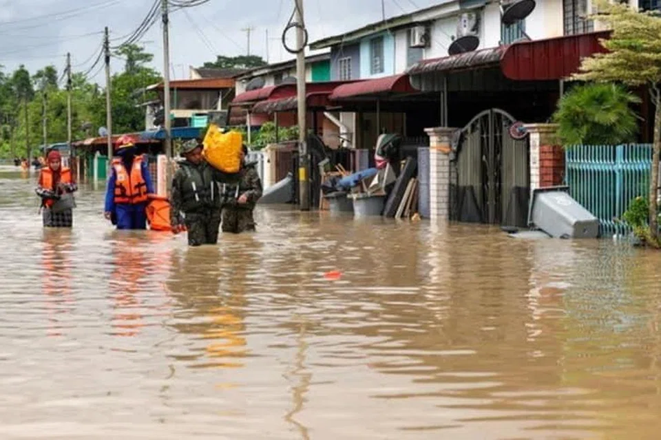 PINDAHKAN MANGSA: Pihak keselamatan membantu mangsa banjir di Kota Tinggi, Johor, berpindah ke pusat pemindahan sementara kerana keadaan banjir semakin buruk pada 8 Januari.