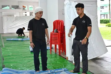 Akif Nur Kafi Nur Ihsan, 18 tahun (kanan), merupakan sukarelawan termuda di Qaryah 21, kariah di kolong Blok 786E, Woodlands Drive 60. 