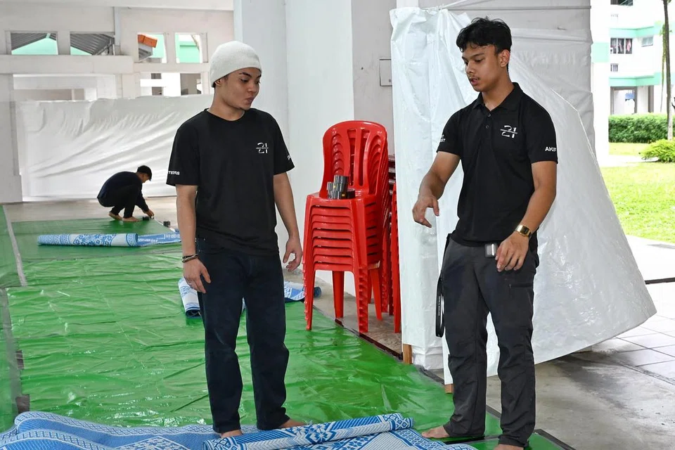 Akif Nur Kafi Nur Ihsan, 18 tahun (kanan), merupakan sukarelawan termuda di Qaryah 21, kariah di kolong Blok 786E, Woodlands Drive 60. 
