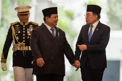 Perdana Menteri Malaysia, Datuk Seri Anwar Ibrahim (kanan) dan Presiden Indonesia, Prabowo Subianto (tengah) berjalan bersama sebelum menghadiri mesyuarat dua hala di Istana Presiden di Jakarta pada 29 Julai 2025.