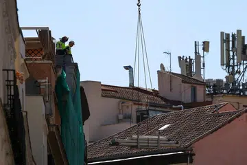 Pekerja berdiri di atas bangunan di tapak runtuhan di pusat Madrid, Sepanyol, 7 Oktober 2025.  