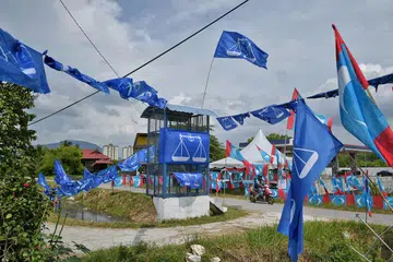 PERANG BENDERA: Bendera dacing Barisan Nasional (BN) dan bendera lambang mata Parti Keadilan Rakyat (PKR) berkibar di Permatang Pauh, Pulau Pinang. Empat parti Pakatan Harapan bertanding di bawah bendera PKR. - Foto BH oleh KUA CHEE SIONG