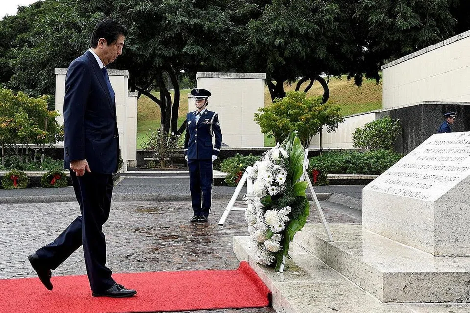 BERI PENGHORMATAN: Perdana Menteri Jepun, Encik Shinzo Abe (kiri) selepas meletakkan jambangan bunga penghormatan di Tugu Peringatan Nasional Pasifik di Punchbowl di Honolulu, Hawaii, kelmarin. - Foto REUTERS