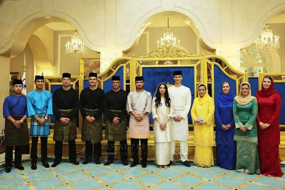 BAGAI PINANG DIBELAH DUA: Tunku Tun Aminah Maimunah Iskandariah Sultan Ibrahim dan Encik Dennis Muhammad Abdullah (ketujuh dan kelapan dari kiri) bergambar bersama anggota keluarga kedua-dua belah pihak. Rakyat Johor dapat menyaksikan secara langsung istiadat persandingan pasangan diraja itu di Bilik Singgahsana, Istana Besar Johor Bahru pada malamnya menerusi layar gergasi yang disediakan di Dataran Bandaraya dan bangunan Majlis Bandaraya Johor Bahru. - Foto PEJABAT AKHBAR KELUARGA DIRAJA JOHOR
