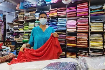 BERUSAHA TAMBAH PENDAPATAN: KERJA SAMBILAN: Cik Jasbir Kaur melakukan kerja sambilan demi menambah pendapatan setelah perniagaan di kedai kainnya merosot 90 peratus disebabkan Covid-19.