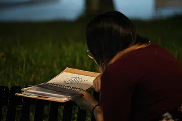 MEMORI TERPAHAT: Cik Sasha membelek jurnal yang ditulis arwah adiknya yang meninggal dunia Februari lalu. - Foto BH oleh KHALID BABA