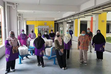 AGIHAN MAKANAN HANGAT DI KEJIRANAN YISHUN: Petugas dan sukarelawan masjid menziarahi penduduk di flat sewa sambil memberikan makanan yang baru dimasak pada hari Ahad ketiga setiap bulan dalam usaha untuk mendampingi penduduk di kawasan Yishun. - Foto-foto MASJID DARUL MAKMUR