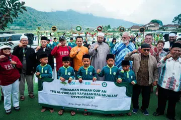 Ustaz Firdaus Masruhen (tengah, berjubah kelabu, berkopiah) pada Program Mualaf,  yang membantu mualaf dengan wakaf Al-Quran dan membayar yuran sekolah mereka, di Bali, Indonesia, pada Februari 2024. 