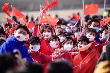 BERJAYA BENDUNG: Gambar yang diambil pada 1 April lalu menunjukkan pasukan bantuan perubatan dari wilayah Liaoning mengibar bendera negara selepas pulang dari menjalankan tugas di Wuhan, China. - Foto AFP