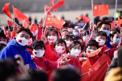 BERJAYA BENDUNG: Gambar yang diambil pada 1 April lalu menunjukkan pasukan bantuan perubatan dari wilayah Liaoning mengibar bendera negara selepas pulang dari menjalankan tugas di Wuhan, China. - Foto AFP