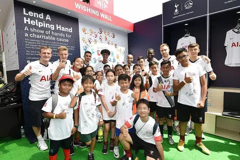 USAHA MURNI: Para pemain bola sepak Tottenham Hotspur (di barisan belakang) bergambar dengan kanak-kanak Children's Wishing Well, yang merupakan pertubuhan kebajikan yang mendapat sokongan AIA Singapore. Acara berlangsung pada Sabtu lalu di Hab Sukan Singapura. - Foto AIA SINGAPORE