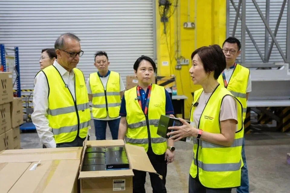 Menteri Kemampanan dan Sekitaran, Cik Grace Fu (depan, kanan), di gudang FairPrice pada pagi 19 Oktober.