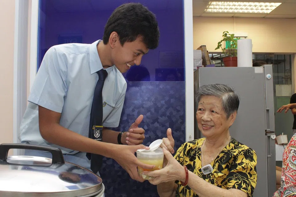 SELESA BERBAKTI: Hazry menawarkan sup kepada salah seorang peserta program Share a Pot, Cik Keo Teck Eng, tanpa masalah meskipun berlainan bangsa. - Foto NHG