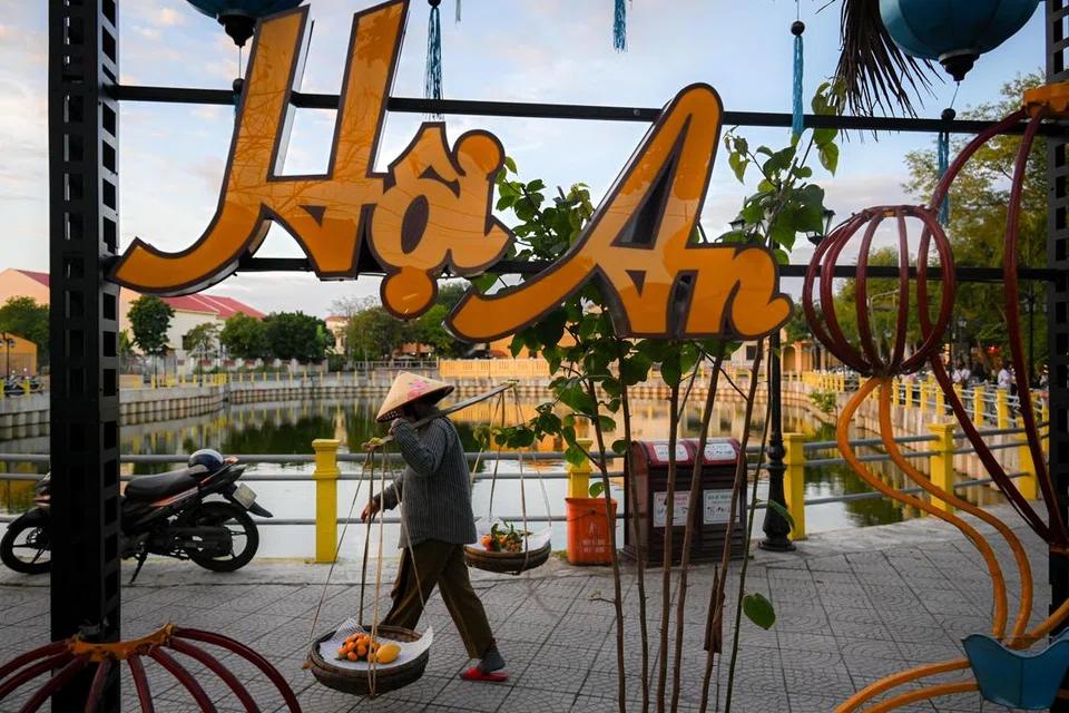 Seorang wanita Vietnam di Hoi An menyandang bakul buah-buahan,  menerapkan tradisi budaya layan diri jalanan.