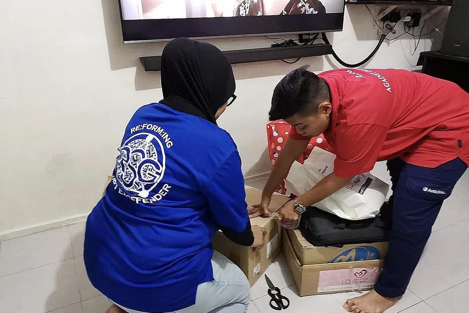 KEMAS BARANG SEBELUM DIPINDAHKAN: Anggota RSG bantu mengemas barang yang dipindahkan menggunakan perkhidmatan pengangkutan kumpulan tersebut. - Foto RSG